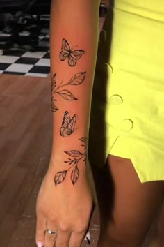 a woman with a butterfly tattoo on her left arm and the other side of her arm