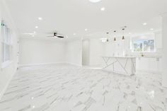 an empty kitchen with marble floors and white cabinets