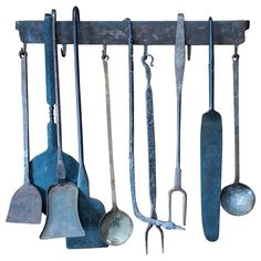 an assortment of kitchen utensils hanging on a wall