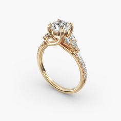 a yellow gold engagement ring with three stones on the band and an oval center stone