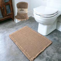 a white toilet sitting next to a brown rug