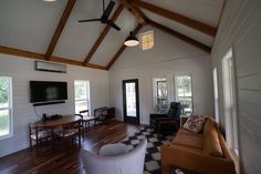 a living room filled with furniture and a flat screen tv mounted on the wall next to a doorway