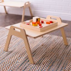 a child's wooden table with toy blocks on it