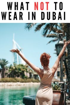 a woman with her arms outstretched standing in front of the water and palm trees that reads, what not to wear in dubai