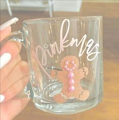 a person holding a coffee mug with a ginger on it's side and pink beads