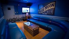 a living room with blue leather couches and a flat screen tv on the wall