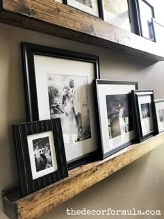 some framed pictures are hanging on a shelf