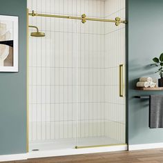 a bathroom with blue walls and white tile on the floor, along with a gold framed shower door