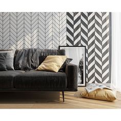 a living room with black and white wallpaper, a couch and pillows on the floor