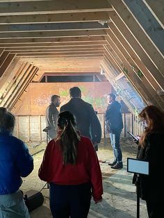 several people standing in an unfinished building looking at something