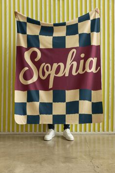 a woman is holding up a towel with the word sophiia on it