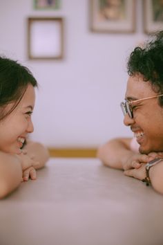 two young women sitting at a table with their arms around each other and laughing together