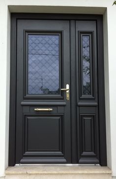 the front door is painted black and has two sidelights on each side, with gold handles