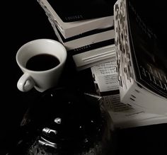 a stack of books sitting next to a cup of coffee