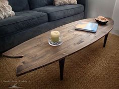 a wooden table sitting on top of a carpeted floor next to a blue couch