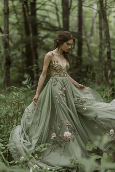 a woman in a green dress walking through the woods