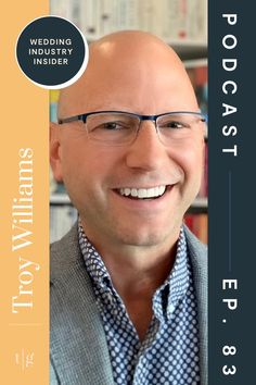 a bald man with glasses smiling for the camera in front of a bookcase and bookshelves