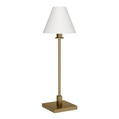 a gold lamp with a white shade on the base and a square shaped light bulb