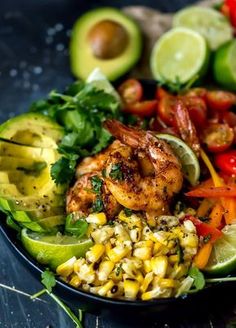 a plate with shrimp, avocado, corn, tomatoes and cilantro