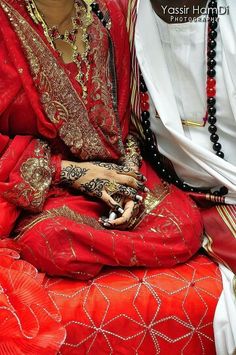 a man and woman dressed in red sitting next to each other