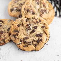 three chocolate chip cookies sitting on top of a table