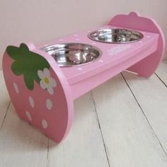 a pink dog bowl stand with two bowls on it