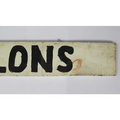 a wooden sign with the word lions painted on it's side and black lettering