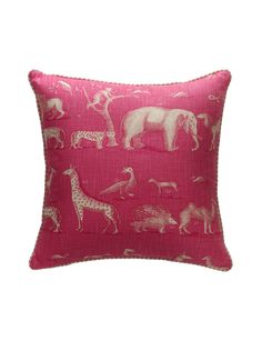 a pink pillow with white elephants and giraffes printed on it's side