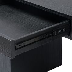 a close up view of a black desk with drawers on the bottom and one drawer open