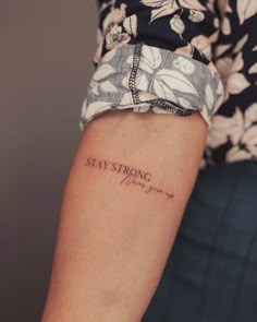 a woman's arm with a tattoo saying stay strong on the left side of her arm