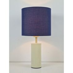 a white table lamp with a blue shade on it's base and a black drum light