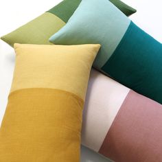 four different colored pillows stacked on top of each other