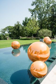 Giant orange reflective floating balls sit atop the water in an outdoor pool to decorate this bridal shower. Wedding Swimming Pool, Orange Balls, Bridal Shower Planning, Stunning Wedding Venues, Bridal Shower Decor, Unique Wedding Decor, Planning Wedding, Pool Decor