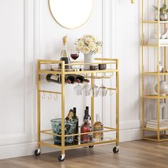 a gold bar cart with wine glasses and bottles