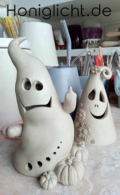 two white ceramic figures sitting on top of a counter next to each other, with the words honigicht de written above them