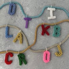 beaded letters and numbers are displayed on the ground with beads in different colors, shapes and sizes