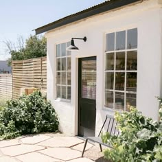 a small white house with black doors and windows