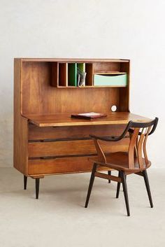 a desk with a chair next to it and a book shelf on the other side