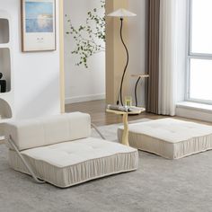 a living room with two white couches and a coffee table in front of a window