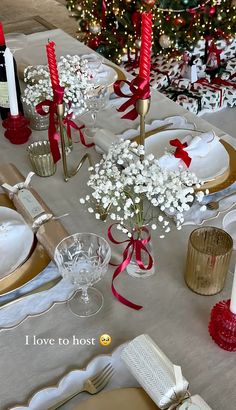 the table is set for christmas dinner with red and white decorations