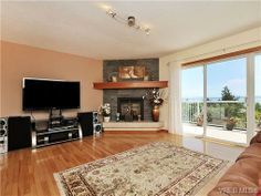 a living room with hardwood floors and a flat screen tv mounted on the wall above a fireplace