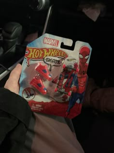 a spider man action figure is in someone's hand