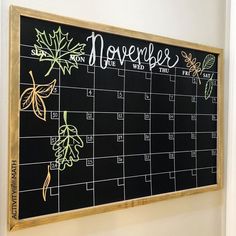 a chalk board with leaves on it and the word november written in white writing below