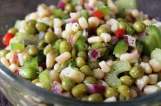 a glass bowl filled with mixed vegetables on top of a table