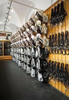 many hats are lined up on the wall in front of each other and hanging from hooks