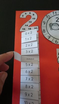 a hand holding up a piece of paper with numbers on it and two times in the middle