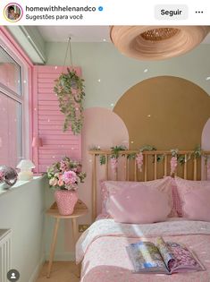 a pink and gold bedroom with flowers on the bed, plants hanging from the ceiling