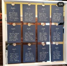 wedding seating chart displayed in white frame with gold trimmings and buttons on blue paper