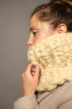 a woman is wearing a wool scarf around her neck