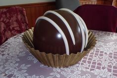 there is a large chocolate ball on the table in front of a red and white chair